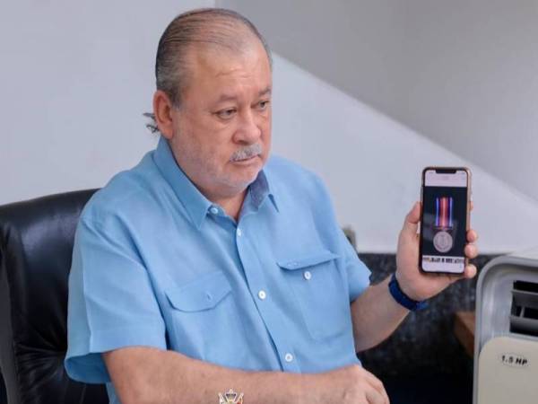 Sultan Ibrahim menunjukkan pingat yang akan dikurniakan kepada petugas barisan hadapan bagi menghargai jasa dan sumbangan mereka. - Foto Royal Press Office