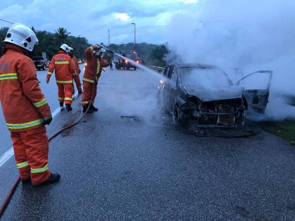 Anggota bomba memadamkan kebakaran Perodua Viva di Kampung Sungai Tong Setiu, petang semalam. - Foto ihsan bomba