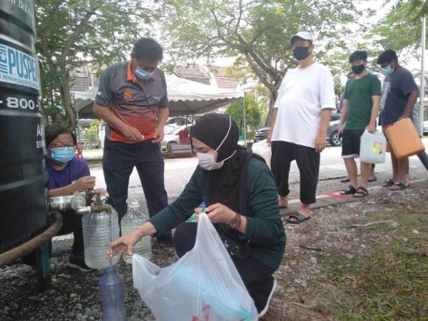 Suriati mengambil bekalan air di PKS USJ4/5 untuk kegunaannya bersama keluarga.