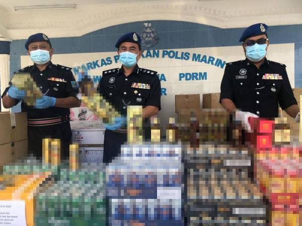 Muhd Zailani (tengah) menunjukkan minuman keras seludup yang dirampas dalam tiga serbuan berasingan sekitar Johor Bahru, di Markas PPM Wilayah 2, Tampoi, Johor Bahru hari ini.