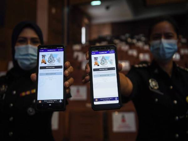 Dua pegawai polis, ASP Norazura Din (kiri) dan ASP Haryanti Che Mat (kanan) menunjukkan aplikasi MULE iaitu apikasi yang boleh mengesan akaun palsu dalam jenayah siber. - Foto Bernama 