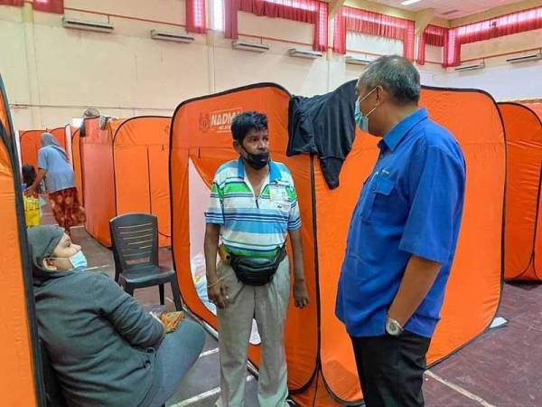 Salleh (kanan) ketika melawat mangsa di pusat pemindahan banjir di Dewan Tun Said, Balai Muhibbah Kampung Baru dan Dewan SMK Taun Gusi 2 hari ini.