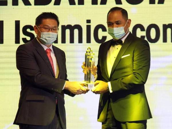 Ban Hong (kiri) menyampaikan Anugerah Kecemerlangan Keperibadian Halal kepada Tun Musa Hitam yang diwakili oleh Ketua Pegawai Eksekutif Iskandar Halal Park (HIP), Ahmad Lokman Ibrahim di Kuala Lumpur kelmarin.