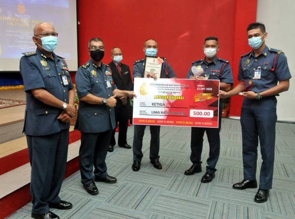 Yahaya (dua dari kiri) menyampaikan hadiah kepada pasukan yang menyertai pertandingan inovasi pada Majlis Perhimpunan Bulanan Jabatan Bomba dan Penyelamat Johor.