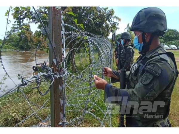Anggota PGA Batalion 7 memeriksa kawat berduri yang dipasang sepanjang Sungai Golok.
