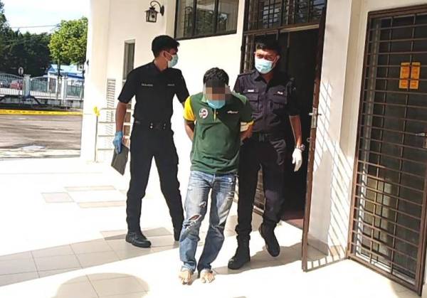Tertuduh dibawa anggota polis ketika di Mahkamah Majistret Kulim hari ini.