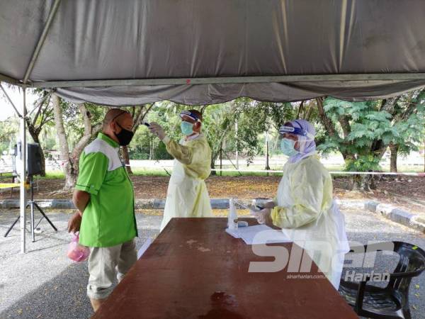 Mangsa banjir yang tiba di pusat pemindahan sementara akan menjalani saringan kesihatan terlebih dahulu sebelum daftar masuk.