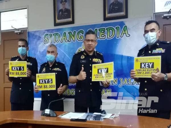 Ismasuhaimi (dua dari kanan) menunjukkan nombor pendaftaran KEY yang merekodkan jumlah bidaan tertinggi melalui sistem (JPJeBid) di Pejabat JPJ Kedah di sini hari ini.