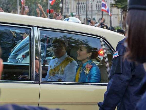 Permaisuri Suthida dan Putera Dipangkorn Rasmijoti yang menaiki kenderaan diraja melepasi para penunjuk perasaan di Bangkok pada 14 Januari lalu. - Foto AFP