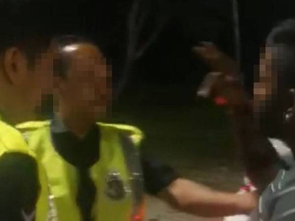 Video yang tular menunjukkan seorang lelaki memarahi anggota polis manakala seorang lagi merakam video dalam kejadian berhampiran Plaza Tol Slim River, di sini, hari ini.