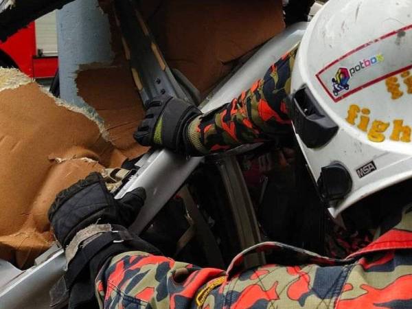 Anggota bomba berusaha mengeluarkan mangsa kemalangan di Kilometer 78 Lebuhraya Utara-Selatan arah utara.