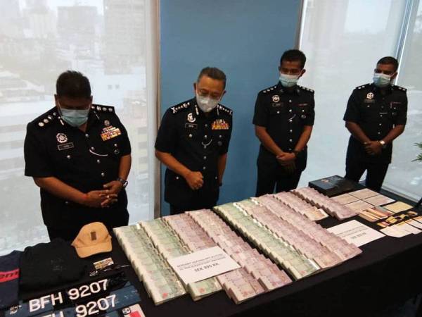 Saiful Azly (dua dari kiri) melihat barangan yang dirampas pada sidang media di IPD Sentul, di sini, hari ini.