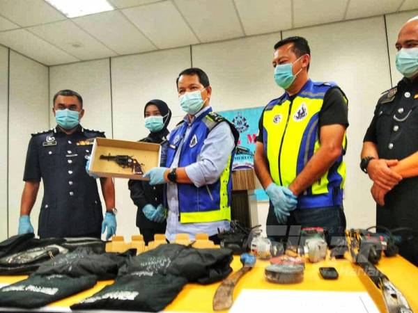 Othman (tiga,kanan) menunjukkan revolver yang ditemui dalam kereta penjenayah terbabit