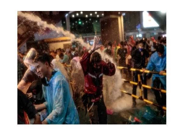 Polis menggunakan meriam air untuk menyuraikan tunjuk perasaan para pelajar yang menuntut pembaharuan dilakukan ke atas monarki di Bangkok pada Ahad lalu. - Foto AFP