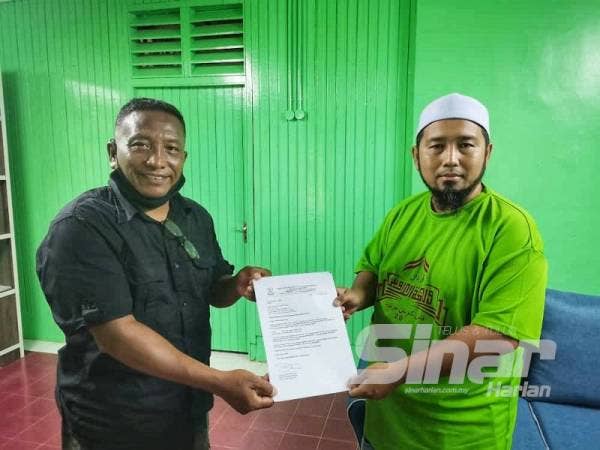Mohd Zakhwan (kanan) menerima petisyen memorandum yang disampaikan wakil Kelab Pencinta Burung Taman Negara, Roslan Abu Kassim semalam.