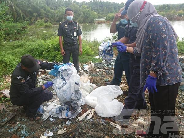 Sapiah (kanan) melihat sisa klinikal yang dibuang di kawasan tapak bekas lombong pasir di Batu Gajah, Sungai Rambai hari ini.