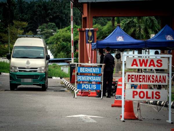 Anggota polis mengawal pintu masuk selepas pelaksanaan Perintah Kawalan Pergerakan Diperketatkan (PKPD) di Kompleks Penjara Seberang Perai hari ini. - Foto Bernama