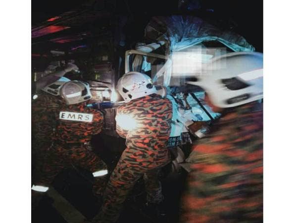 Anggota bomba mengeluarkan seorang pemandu lori ikan yang tersepit di tempat duduknya selepas terlibat kemalangan dengan sebuah treler di Kilometer 147 Lebuhraya Utara-Selatan, Tangkak malam tadi.