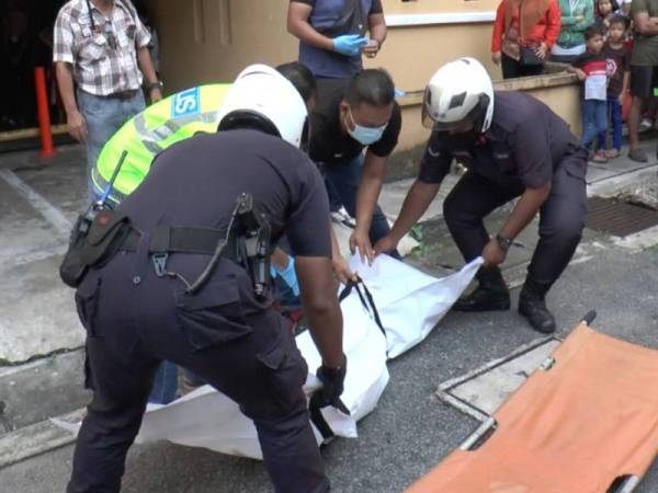 Anggota polis mengangkat mayat mangsa di lokasi kejadian.