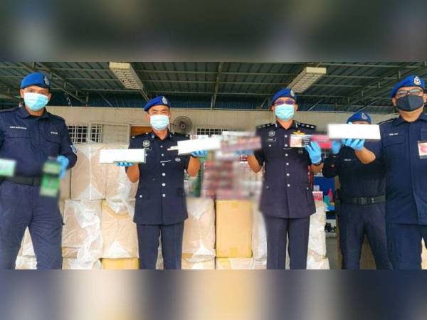 Norzaid (tiga dari kiri) bersama anggotanya menunjukkan sebahagian daripada 3.29 juta batang rokok seludup yang dirampas.