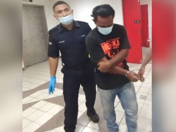 Tertuduh (kanan) semasa dibawa ke Mahkamah Majistret Kuala Terengganu hari ini.