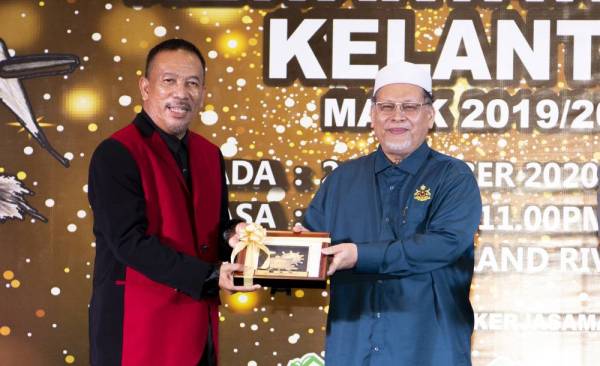 Mohd Amar (kanan) menyampaikan Anugerah Khas Wartawan Cemerlang kepada Ketua Biro Pertubuhan Berita Nasional Malaysia (Bernama) Kelantan, Zabidi Ishar (kiri) pada Malam Anugerah Kewartawanan Kelantan (MAKK) 2019/2020 malam tadi. - Foto Bernama