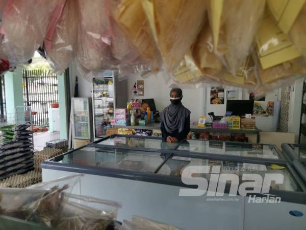 Zuhairah menanti pelanggan datang ke kedai tempatnya bekerja