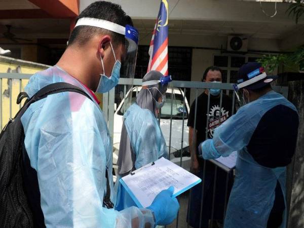 Angkatan Pertahanan Awam Malaysia bersama petugas kesihatan melakukan pemeriksaan dari rumah ke rumah ketika tinjauan di kawasan Perintah Kawalan Pergerakan Diperketat (PKPD) di kawasan rumah teres Jalan Emas 31 dan Jalan Emas 32, Kuala Langat hari ini. - Foto Bernama
