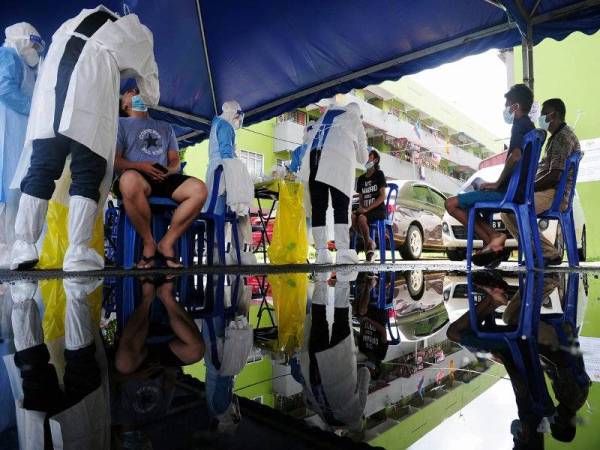 Petugas kesihatan melakukan ujian saringan COVID-19 ke atas penduduk yang tinggal di kawasan yang dikenakan PKPD ketika tinjauan di Flat Sungai Emas, Kuala Langat hari ini. - Foto Bernama