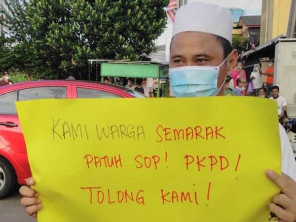 Penduduk Taman Semarak di Tawau hari ini menunjukkan tulisan pada kad manila bahawa mereka memerlukan bantuan sepanjang PKPD di kawasan itu dilaksanakan.