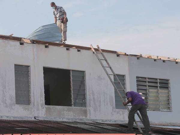 Penduduk melihat kerosakan yang dialami akibat kejadian ribut dan hujan lebat di Taman Perumahan Indera Mahkota 2, Kuantan malam tadi.