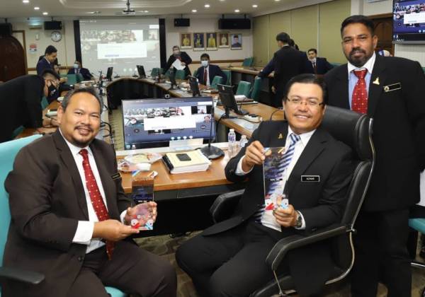 Mohd Azhar (tengah) menunjukkan anugerah emas yang dibawa pulang pasukan MDHS.