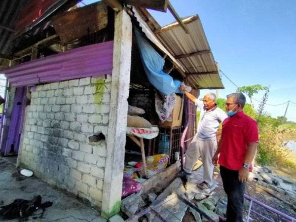Hassan (dua dari kanan) bersama Ketua Parti Pribumi Bersatu Malaysia Bahagian Jerlun, Abdul Ramli melihat sebahagian dinding warung yang runtuh Selasa lalu.