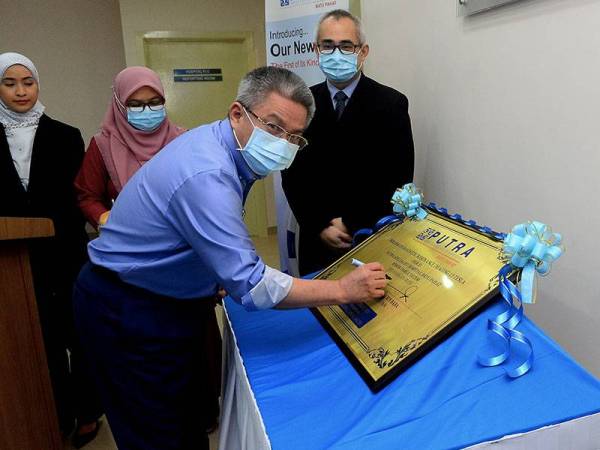 Menteri Kesihatan, Datuk Seri Dr Adham Baba menandatangani plak perasmian Bilik Magnetic Resonance Imaging (MRI) dan Mesin MRI baharu di Putra Specialist Hospital Batu Pahat hari ini. - Foto Bernama