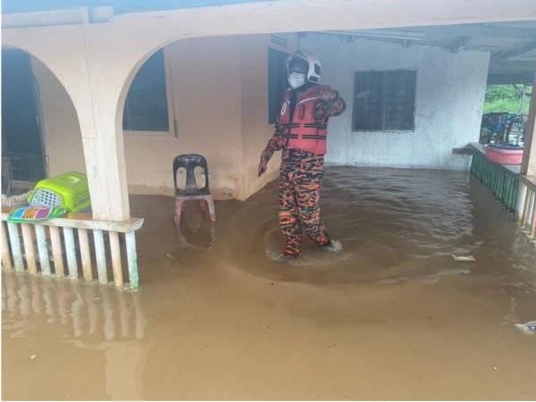 Pihak bomba melakukan pemeriksaan dan memindahkan mangsa banjir kilat di Kampung Bukit Raja ke PPS Sekolah Kebangsaan Teluk Ramunia, Pengerang, Kota Tinggi, hari ini.