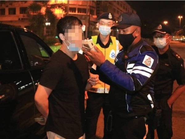 Pegawai Bahagian Siasatan dan Penguatkuasaan Trafik menggunakan EBA untuk menguji kandungan alkohol pemandu kereta ketika ditahan dalam Op Mabuk semalam. - Foto PDRM
