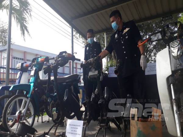  Mulkiaman (kanan) menunjukkan sebuah motosikal yang telah dibuka komponen oleh geng Bing Garage di IPD Padang Terap hari ini. 