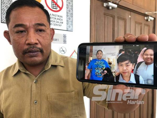 Mohd Amin Yasin menunjukkan gambar anaknya, Cik B dan Kacak.