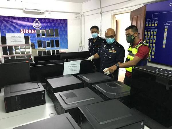 Pihak polis menunjukkan barang yang dirampas di sebuah rumah di Taman Pelindung.