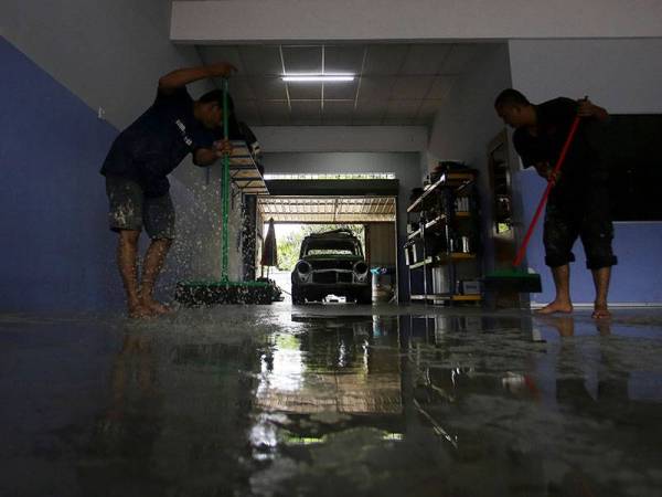 Dua pekerja sebuah bengkel dilihat sibuk membersihkan ruangan bengkel tersebut berikutan ditenggelami banjir lumpur susulan hujan lebat sejak pukul 12.45 malam tadi ketika tinjauan fotoBernama di sekitar Rantau hari ini.