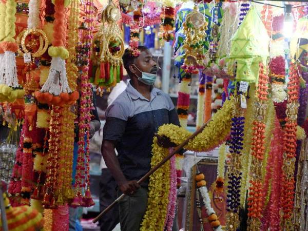 Seorang peniaga kelihatan sibuk mempamerkan barangan hiasan Deepavali di gerainya di Lebuh Pasar atau lebih dikenali Little India, Georgetown hari ini. Foto Bernama