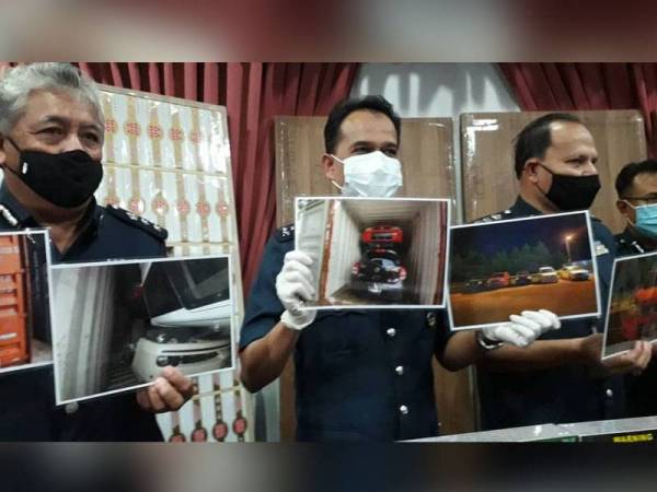 Sazali (tengah) menunjukkan gambar lima kereta yang ditemui dalam kontena yang diikrarkan kosong pada sidang media di Menara JKDM Johor, Johor Bahru hari ini.