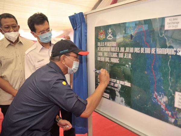 Wan Rosdy (kanan) menyempurnakan majlis perasmian projek pembinaan jalan Pos Betau-Kampung Semoi Lama di Pos Betau di sini hari ini.