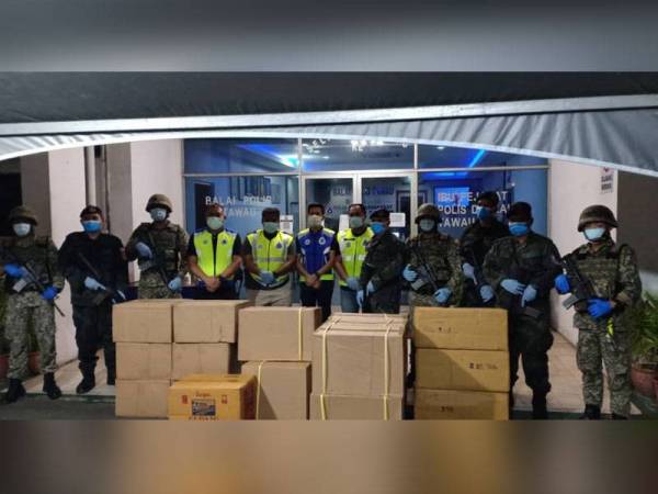 Anggota ESSCOM menunjukkan rokok seludup yang berjaya dirampas di Blok 5, Kampung Titingan Tawau.