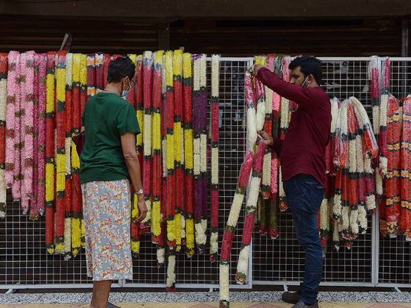 Kelihatan seorang peniaga melayan pelanggan bagi persiapan menjelang Deepavali sambil mengamalkan Prosedur Operasi Standard (SOP) bagi mengekang pandemik COVID-19 ketika tinjauan di Little India hari ini.