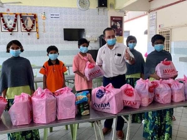 Jagdeep (tengah) menyampaikan sumbangan sempena sambutan Deepavali di Asrama Ramakrishna hari ini.