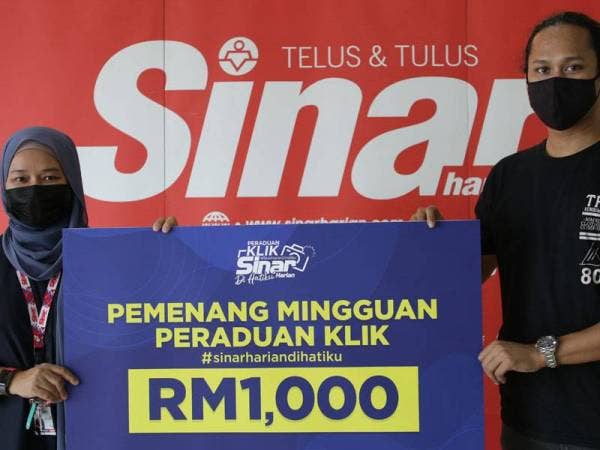 Farah Hussamuddin (kiri) menyerah hadiah kepada Rifqie Zhariff di Kompleks Kumpulan Karangkraf, di sini baru-baru ini.