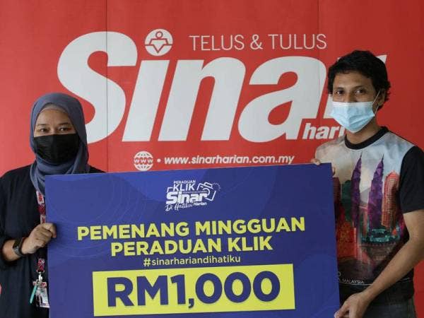 Farah (kiri) menyerahkan hadiah kepada wakil pemenang, Mohd Ramzi Hazam di Kompleks Kumpulan Karangkraf, di sini baru-baru ini.