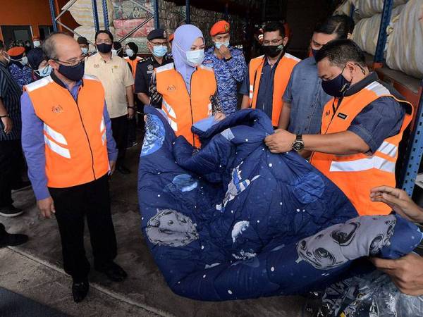 Menteri Pembangunan Wanita, Keluarga dan Masyarakat Datuk Seri Rina Mohd Harun melihat selimut yang disediakan untuk mangsa bencana ketika melawat Depoh Simpanan Keperluan Bencana Zon Selatan di Parit Keroma hari ini.