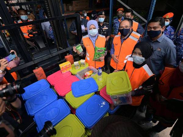 Menteri Pembangunan Wanita, Keluarga dan Masyarakat Datuk Seri Rina Mohd Harun melihat barang makan yang dipunggah masuk bagi persediaan bencana ketika melawat Depoh Simpanan Keperluan Bencana Zon Selatan di Parit Keroma hari ini.